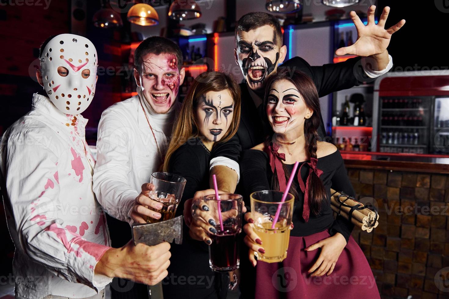 Posing for the camera. Friends is on the thematic halloween party in scary makeup and costumes photo