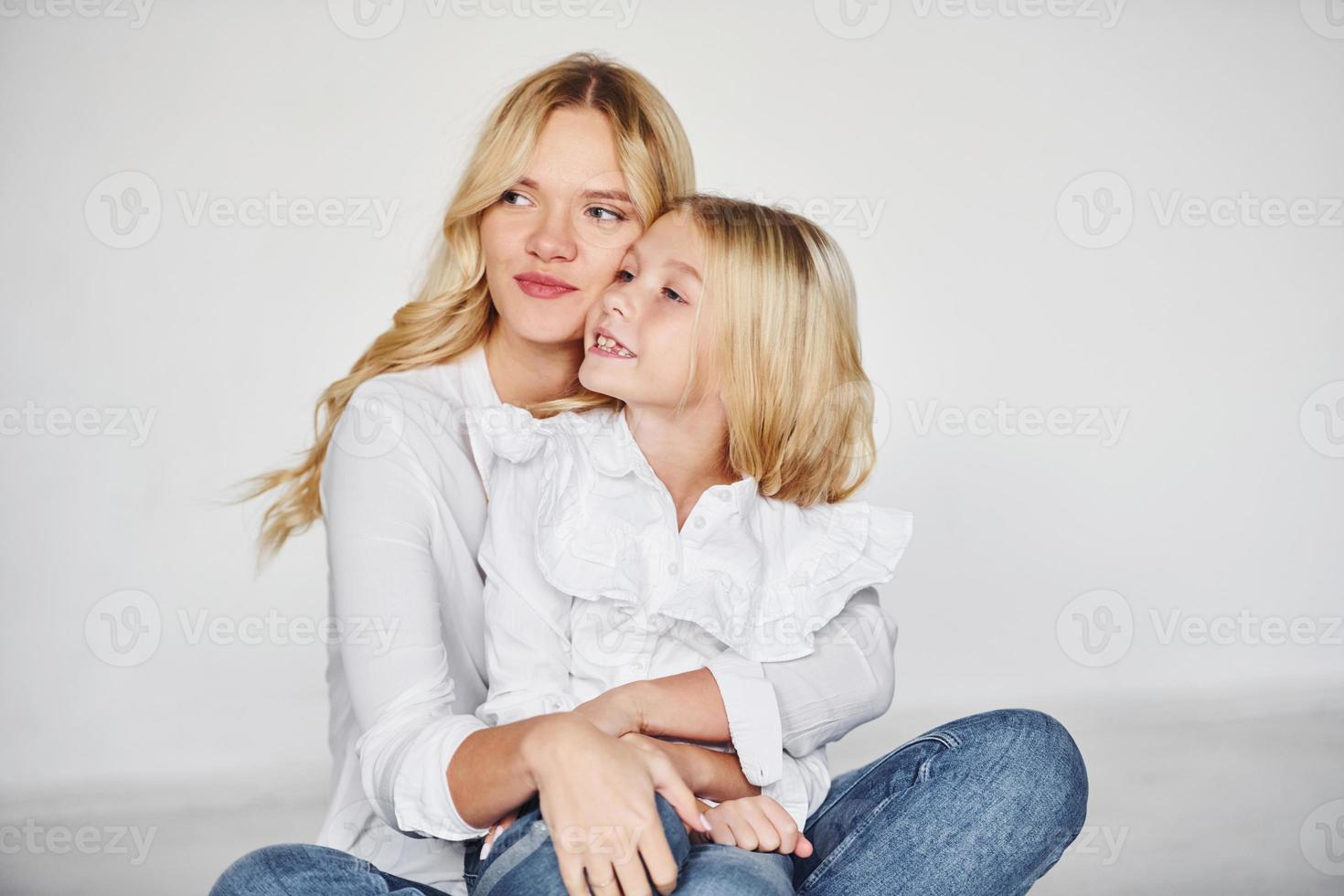 madre con su hija se divierten juntas en el estudio con fondo blanco foto