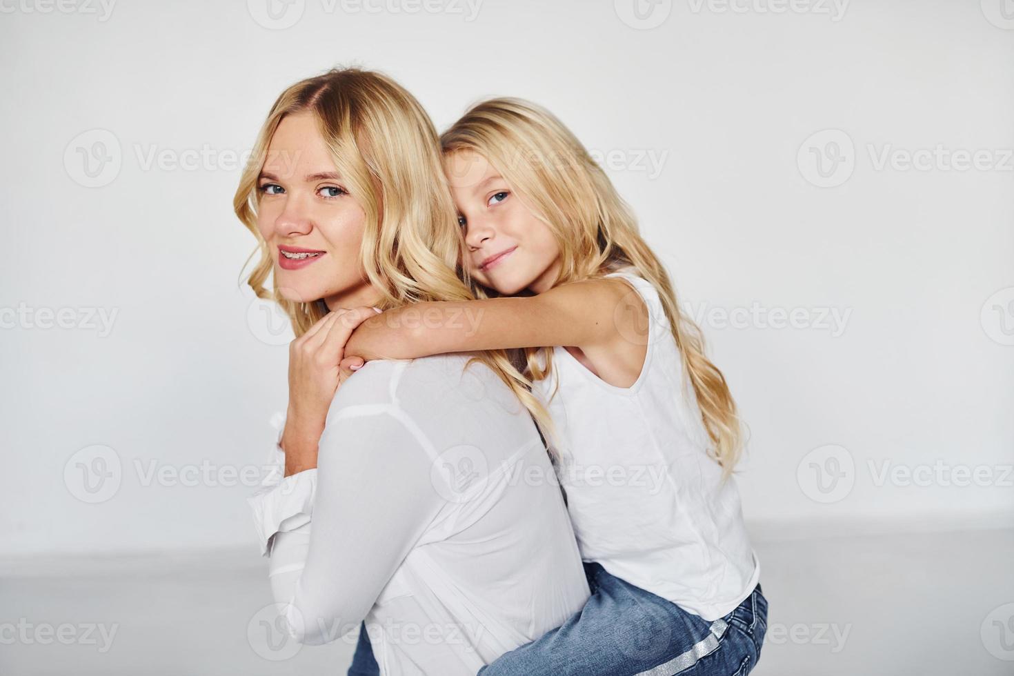 Mother with her daughter have fun together in the studio with white background photo