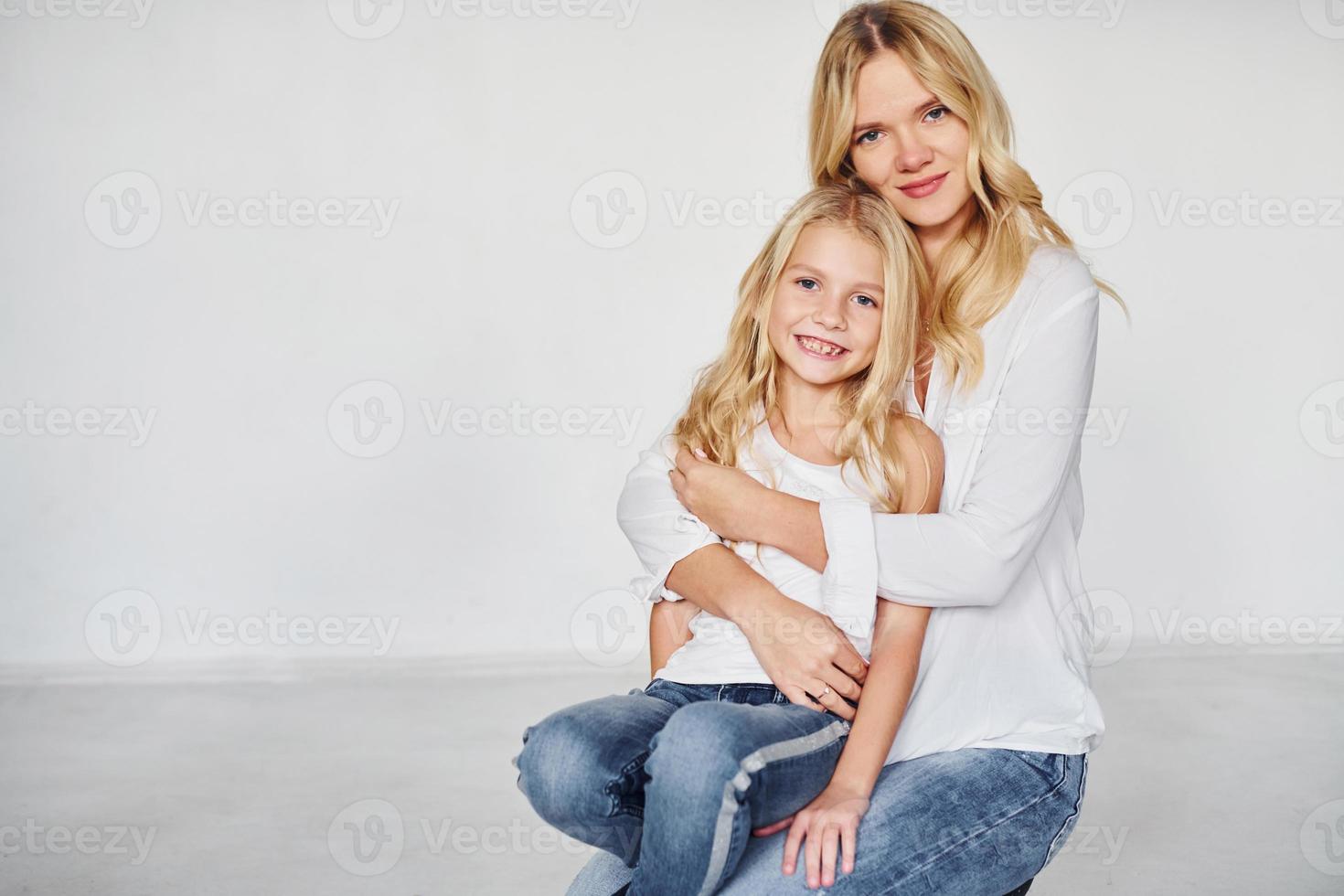 madre con su hija se divierten juntas en el estudio con fondo blanco foto