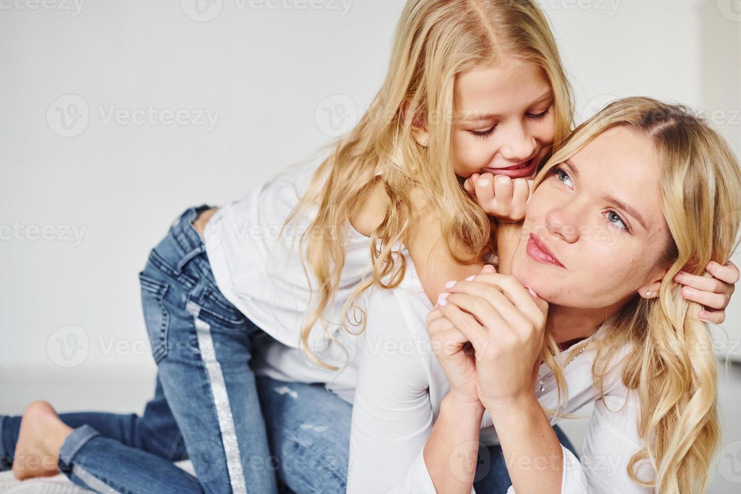 madre con su hija juntas en el estudio con antecedentes blancos foto