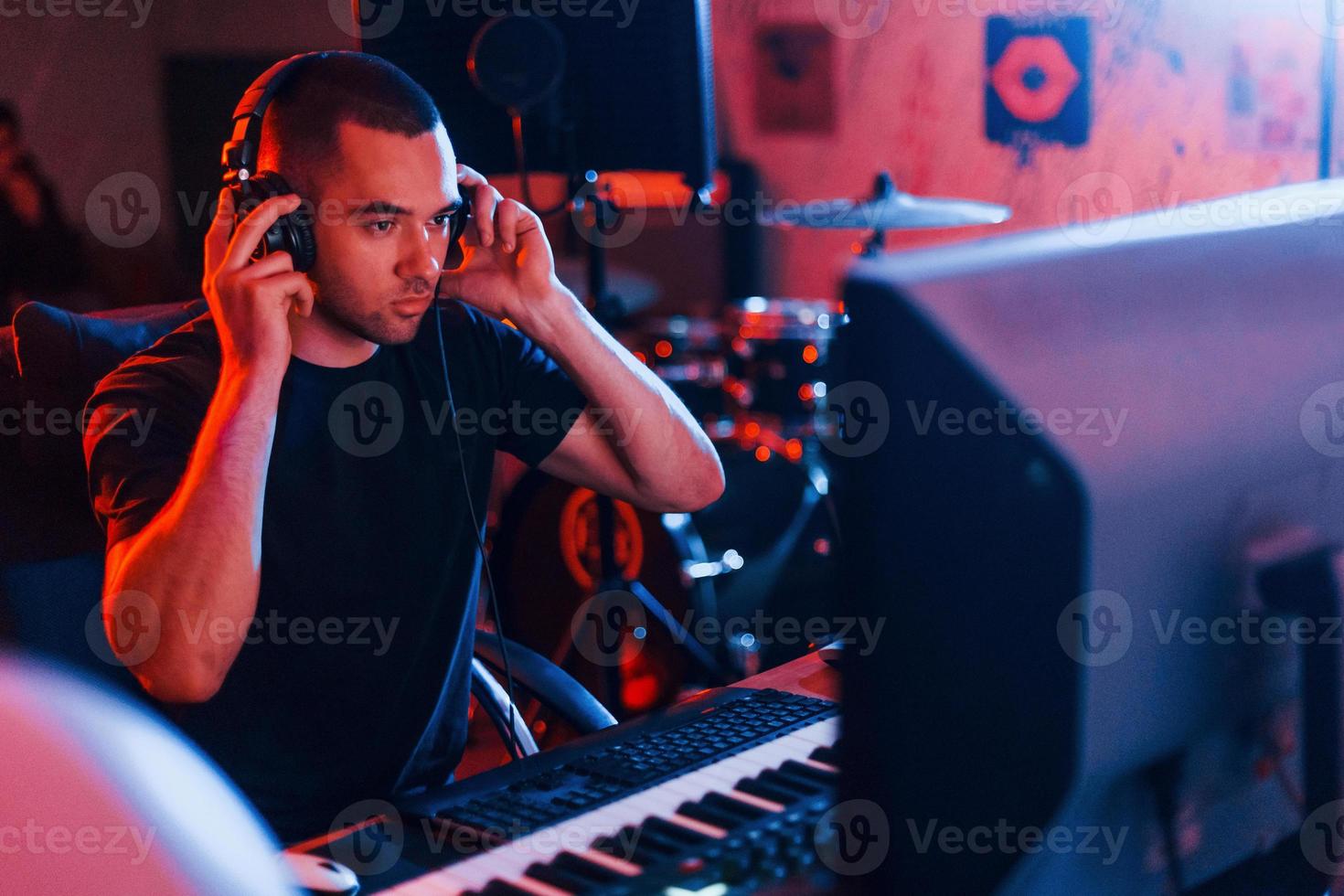 Sound engineer in headphones working and mixing music indoors in the studio photo