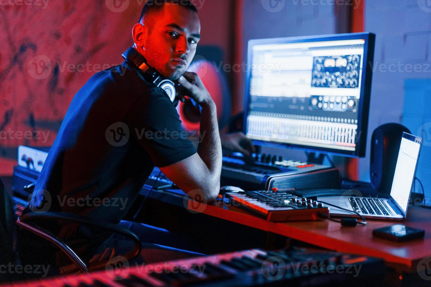 Guy have a job with project and mixing music indoors in the studio photo