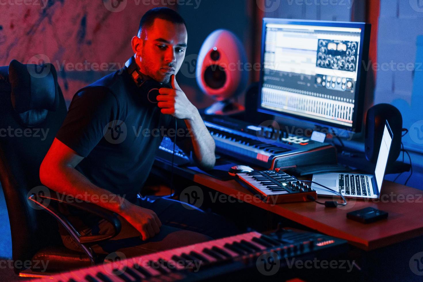 Guy have a job with project and mixing music indoors in the studio photo