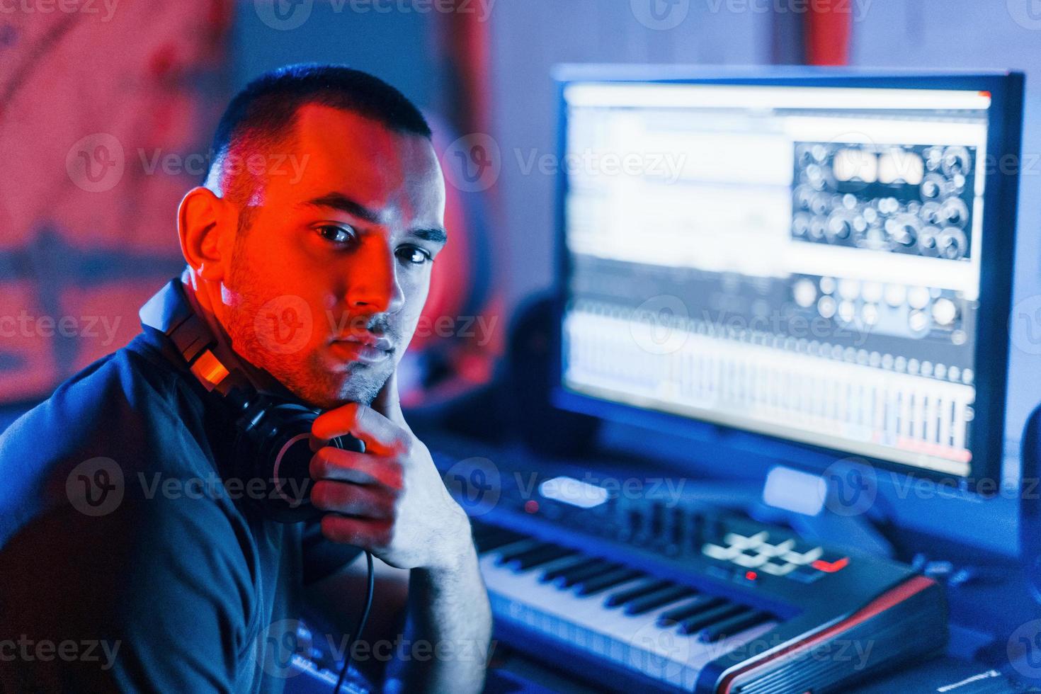 Guy have a job with project and mixing music indoors in the studio photo