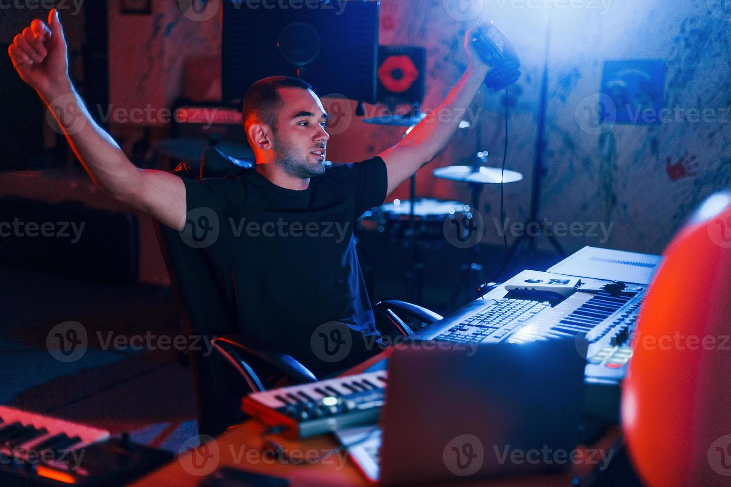 Guy have a job with project and mixing music indoors in the studio photo