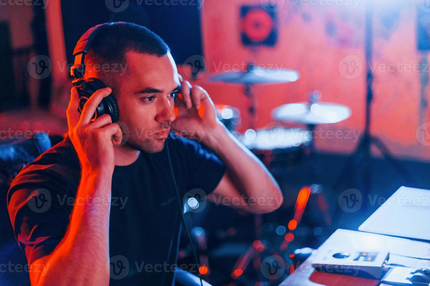 Sound engineer in headphones working and mixing music indoors in the studio photo