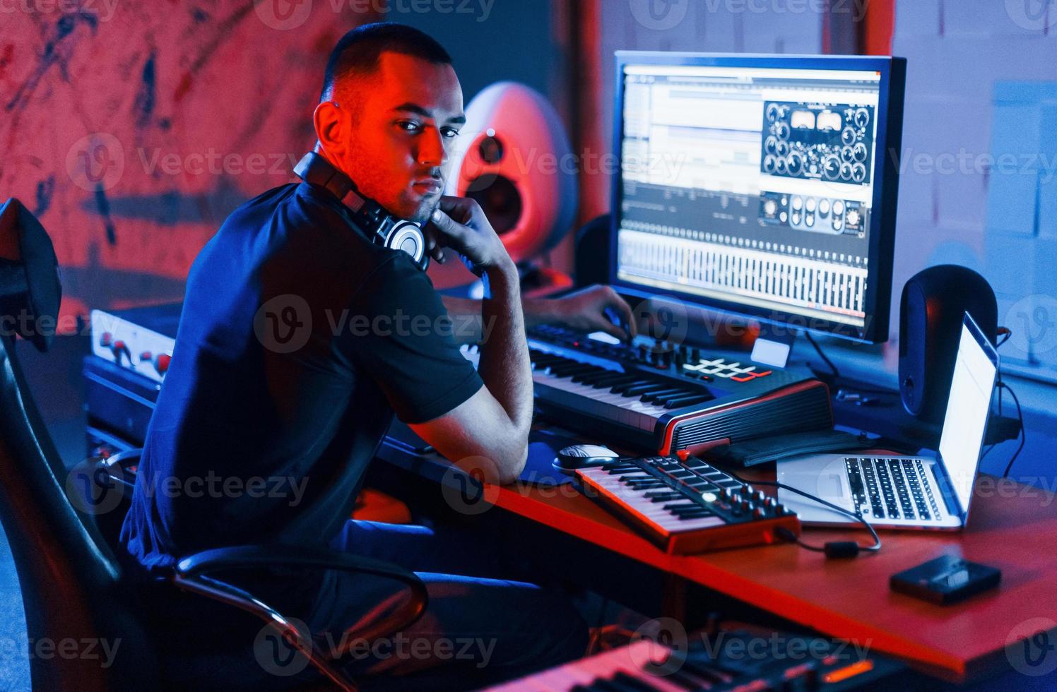 Guy have a job with project and mixing music indoors in the studio photo