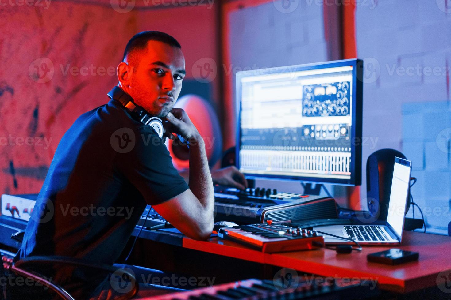 Guy have a job with project and mixing music indoors in the studio photo