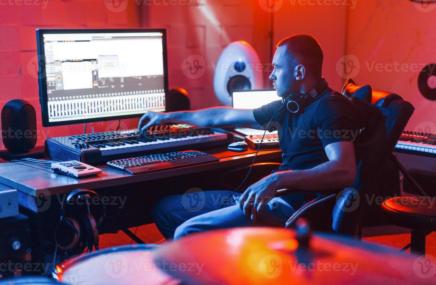 Guy have a job with project and mixing music indoors in the studio photo
