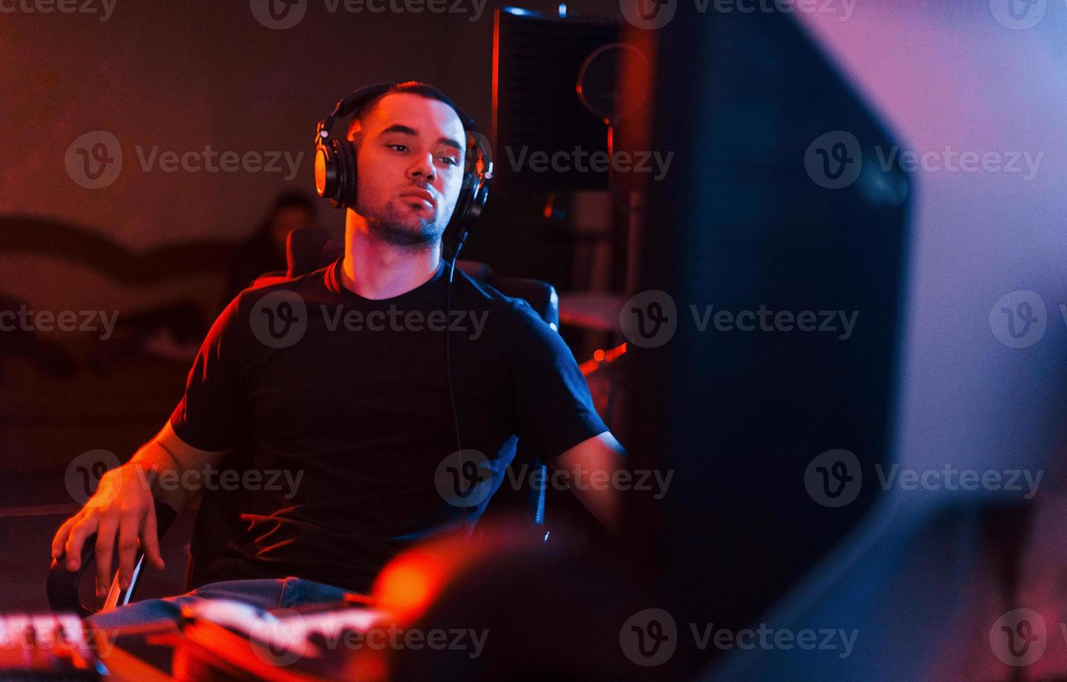 Sound engineer in headphones working and mixing music indoors in the studio photo