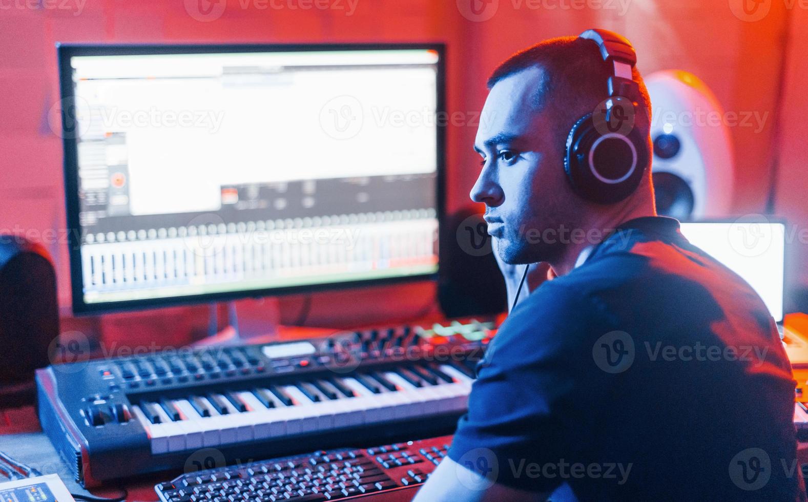 Sound engineer working and mixing music indoors in the studio near drum kit photo