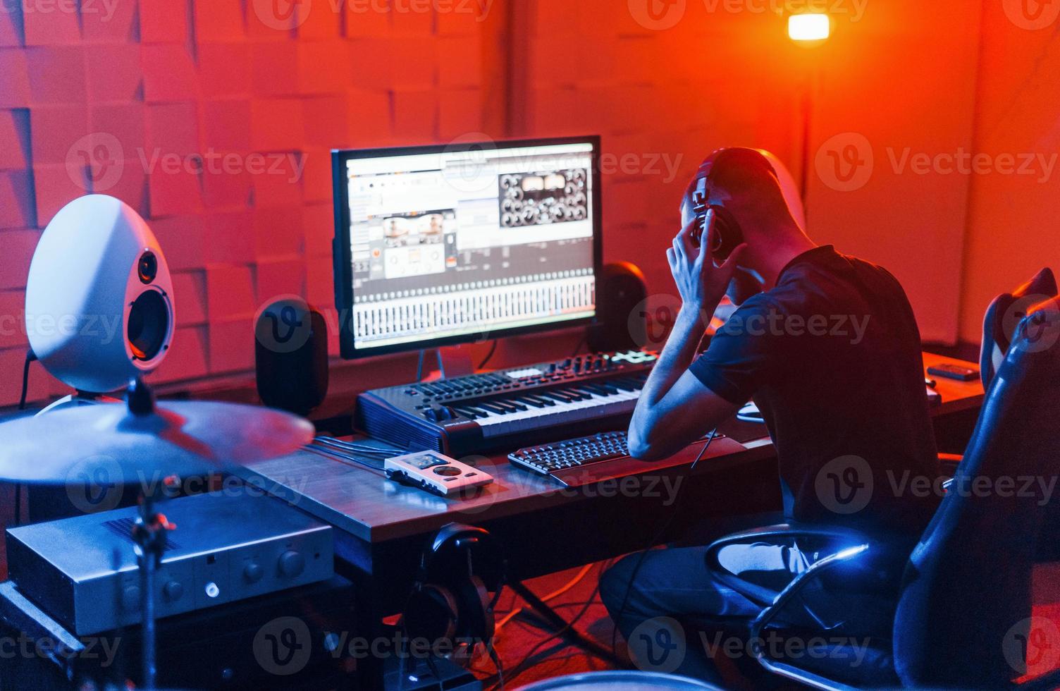 Guy have a job with project and mixing music indoors in the studio photo
