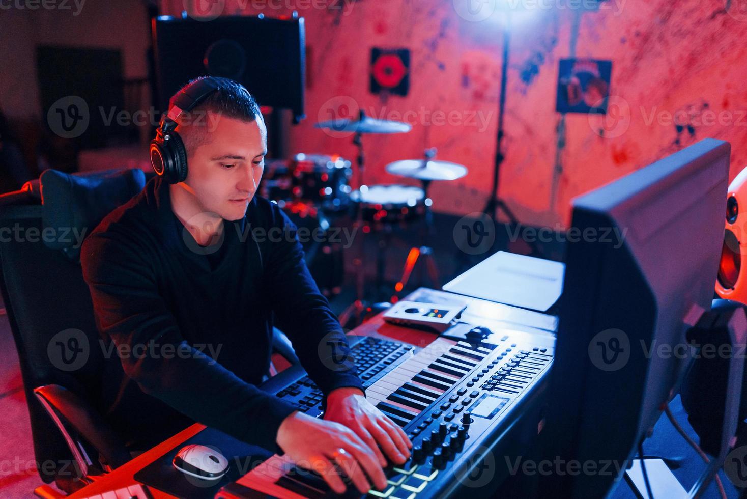 Young soung engineer working and mixing music indoors in the studio photo