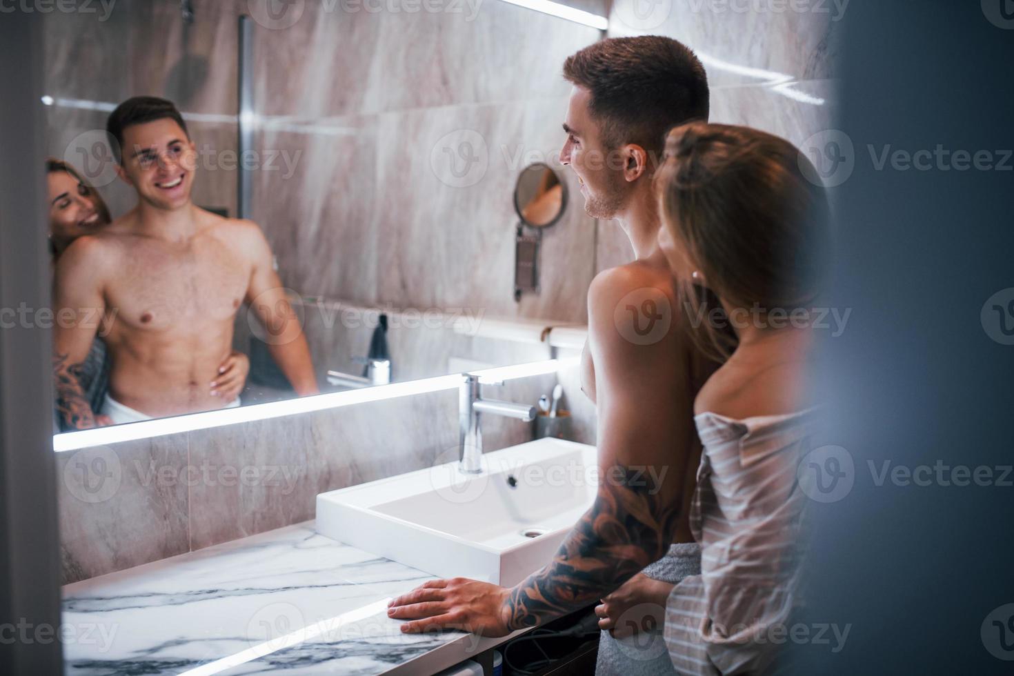 Young couple together in the bathroom at morning time photo