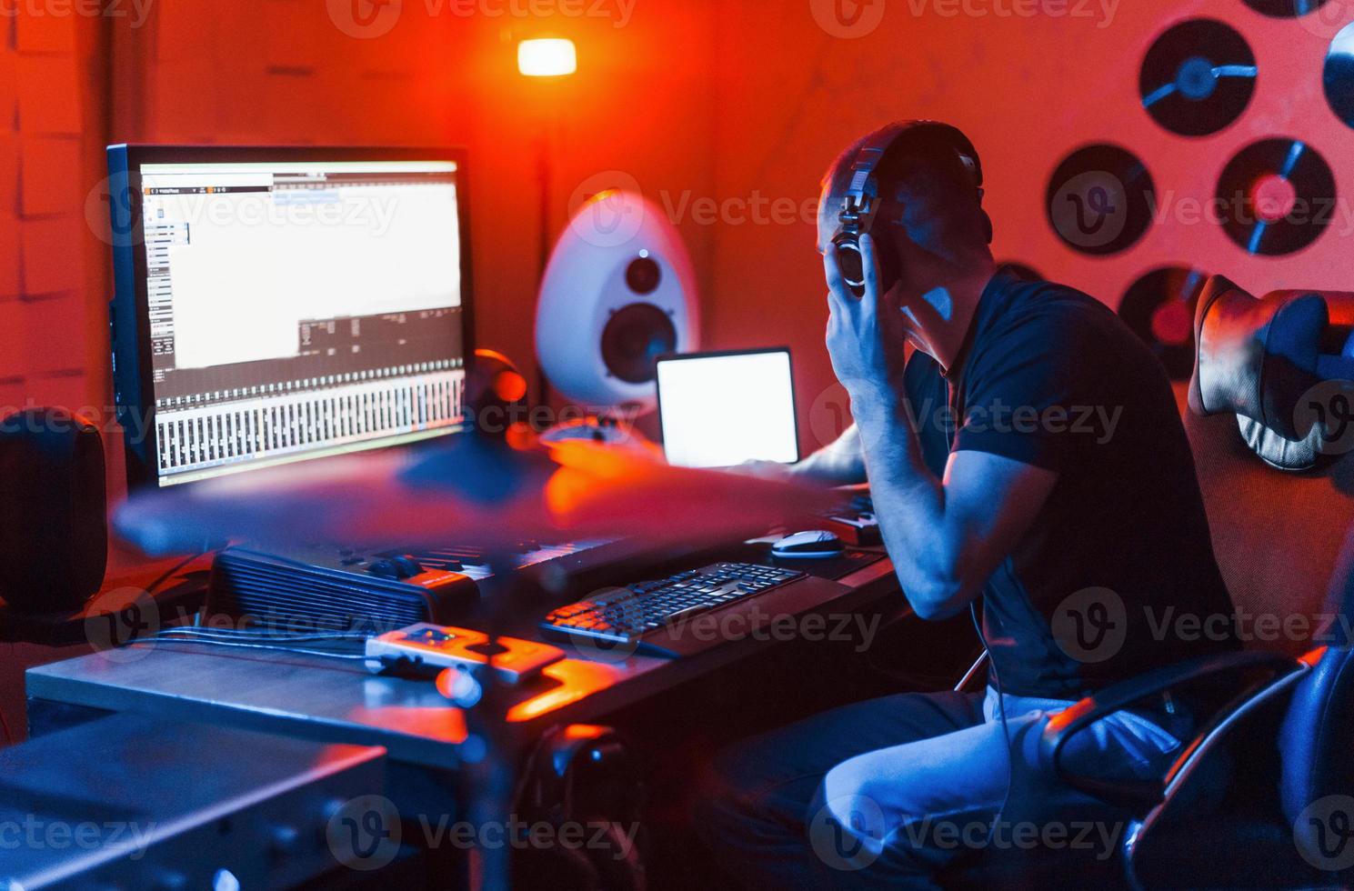 Guy have a job with project and mixing music indoors in the studio photo