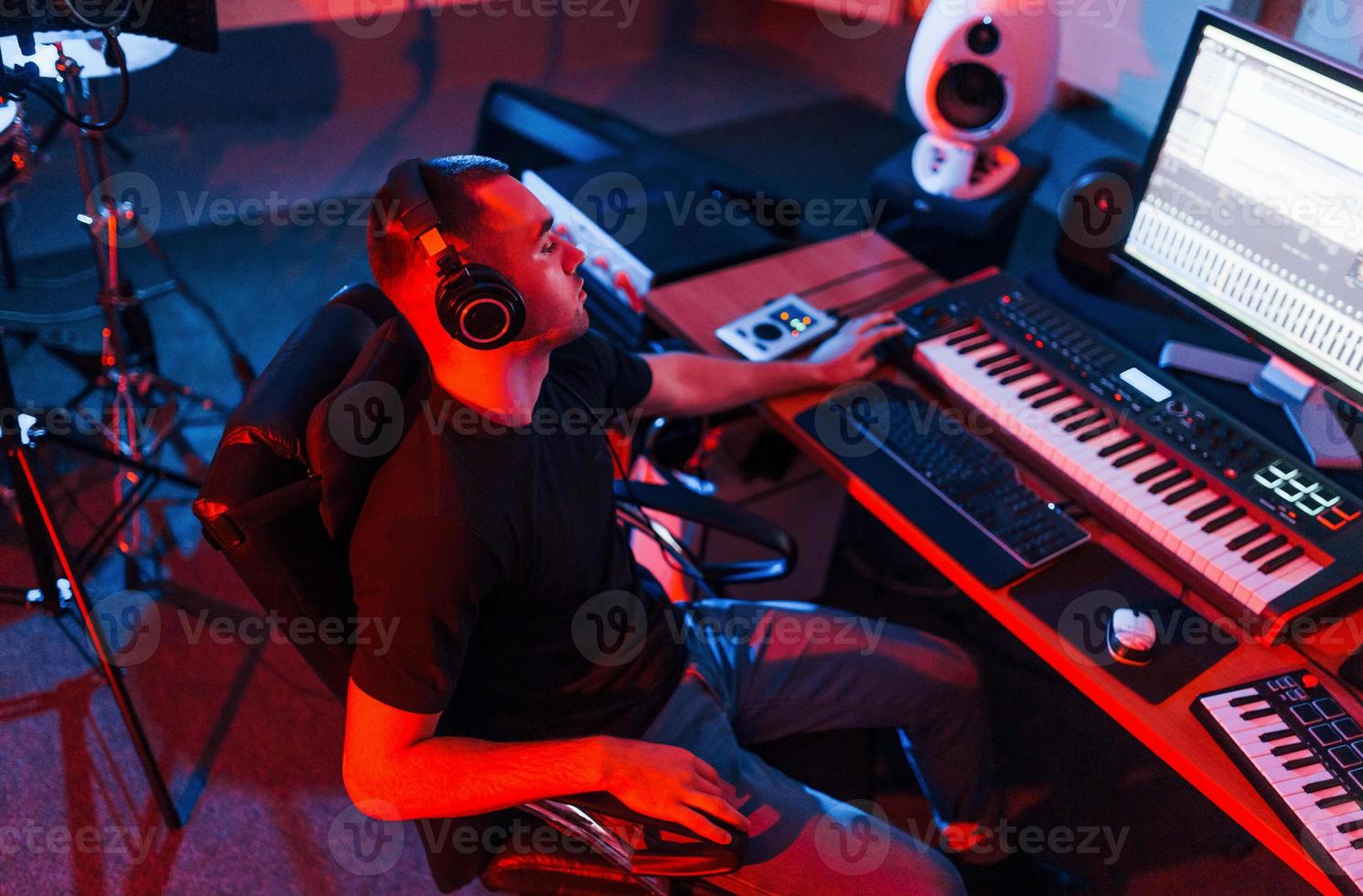 Professional sound engineer working and mixing music indoors in the studio photo