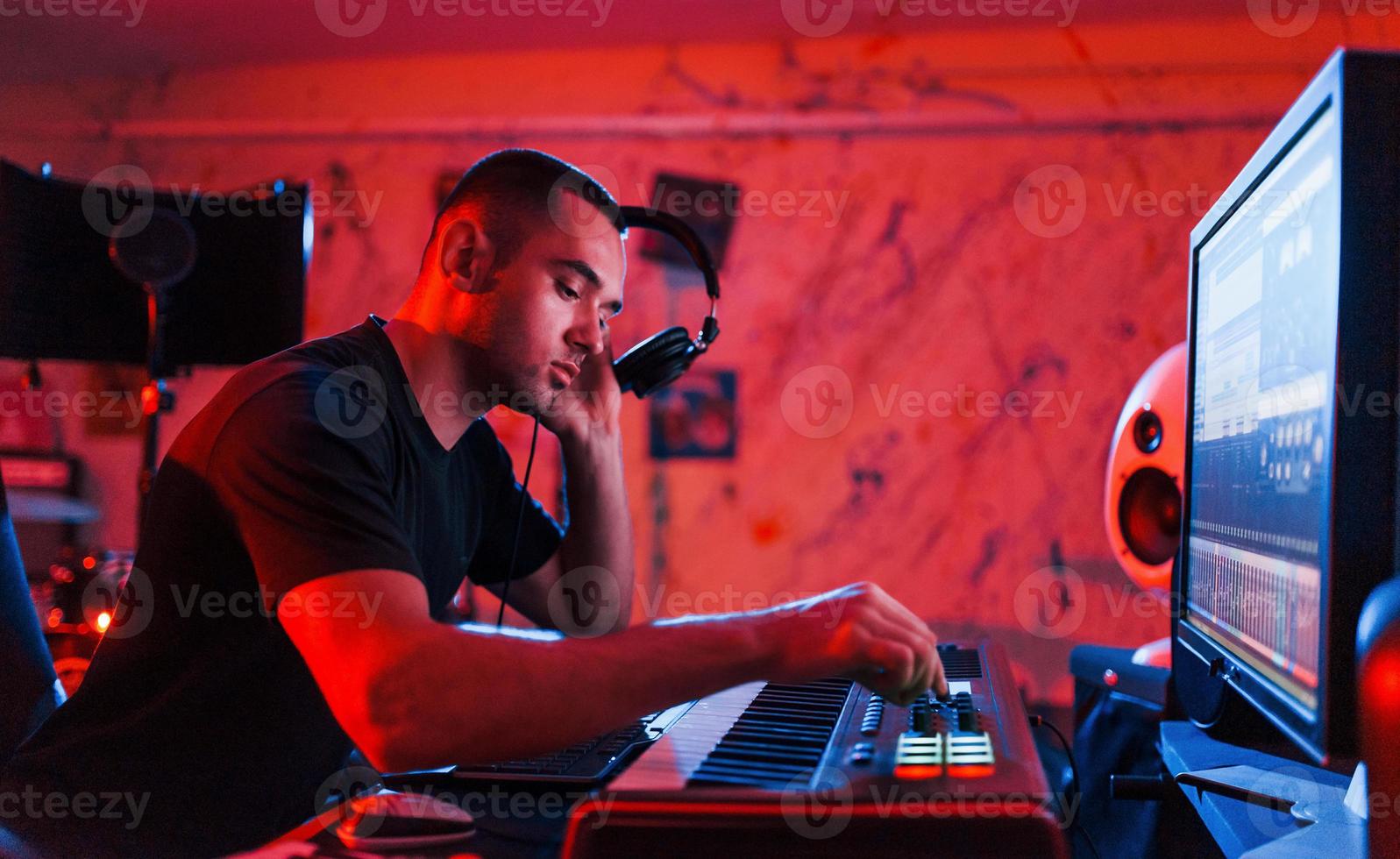 Professional sound engineer working and mixing music indoors in the studio photo
