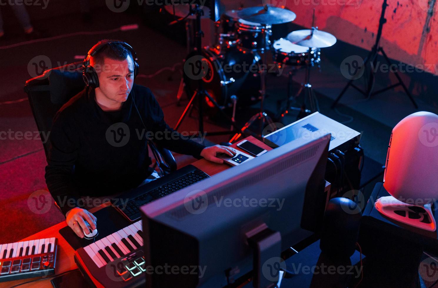 joven ingeniero de sonido trabajando y mezclando música en interiores en el estudio foto