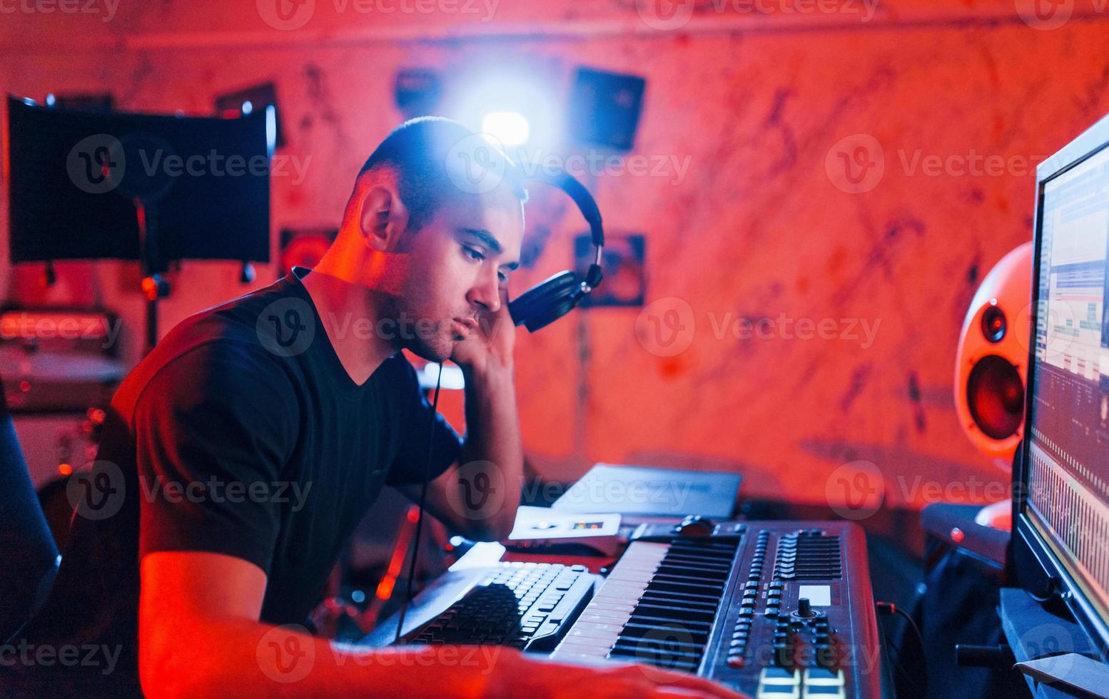 Professional sound engineer working and mixing music indoors in the studio photo