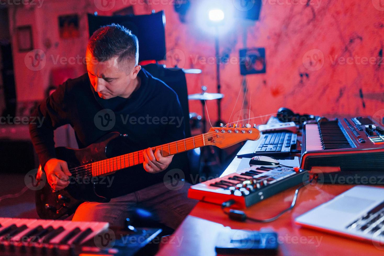 Guitar player have recording session indoors in the studio photo