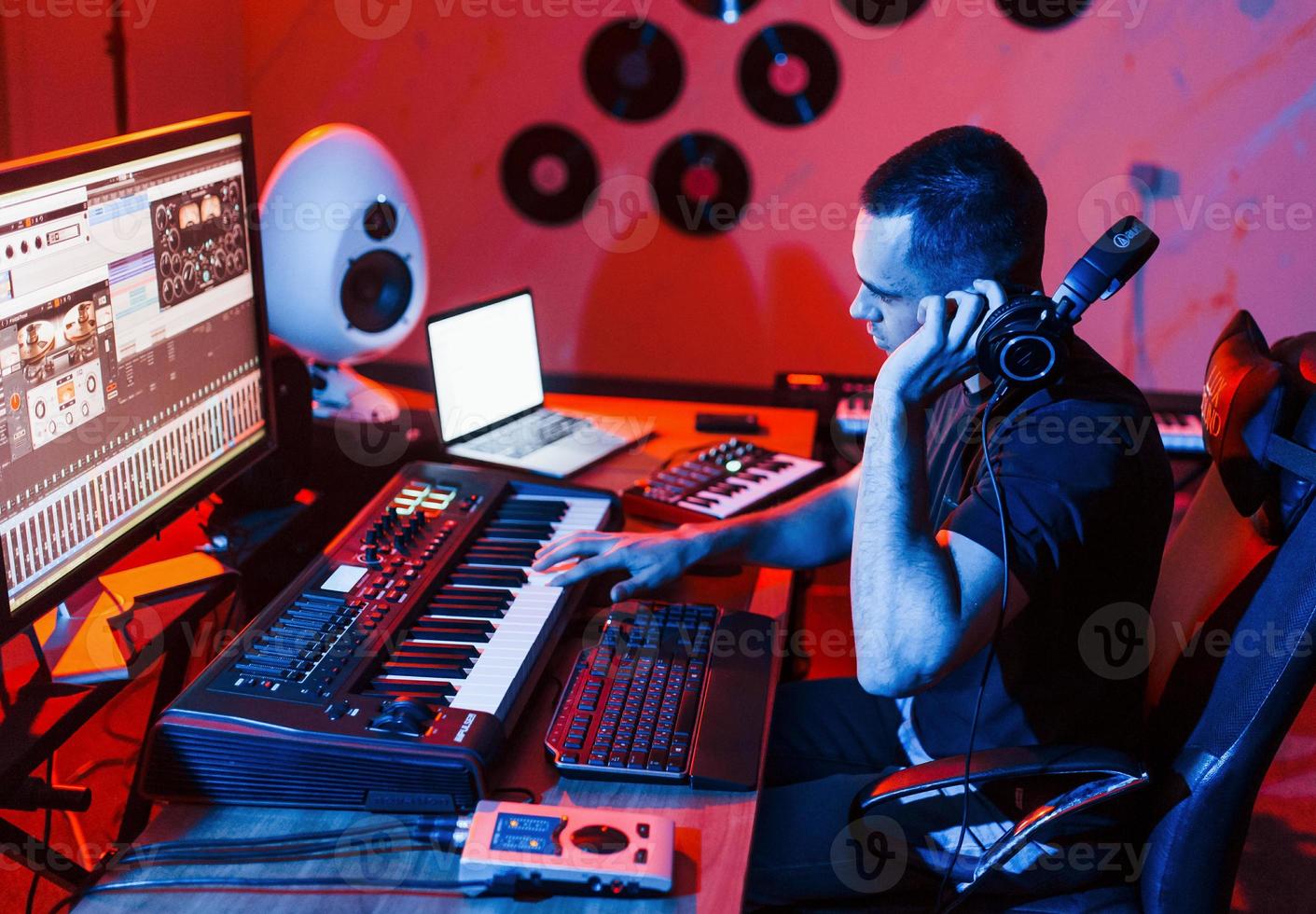 joven ingeniero de sonido trabajando y mezclando música en interiores en el estudio foto