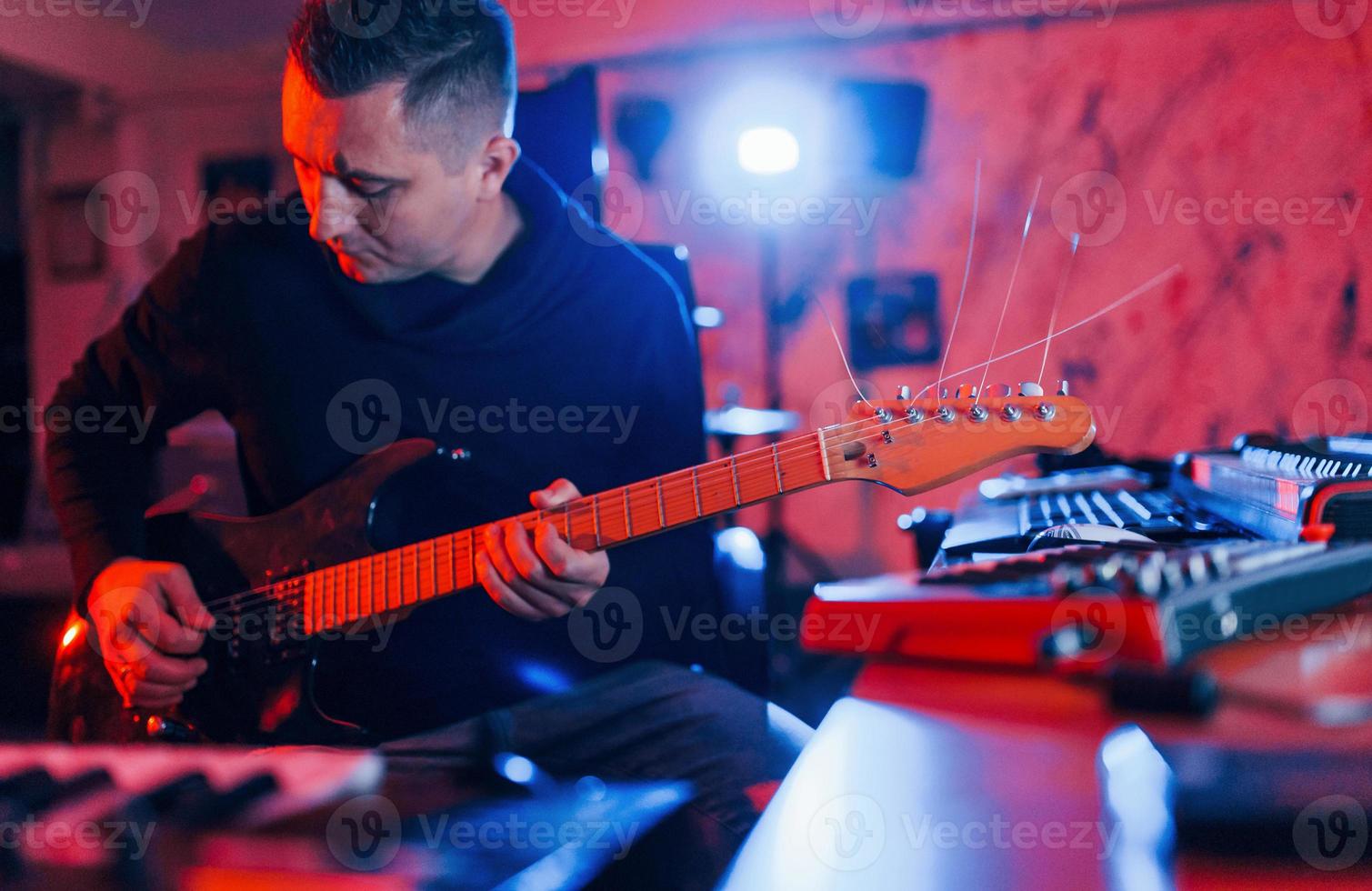 Guitar player have recording session indoors in the studio photo