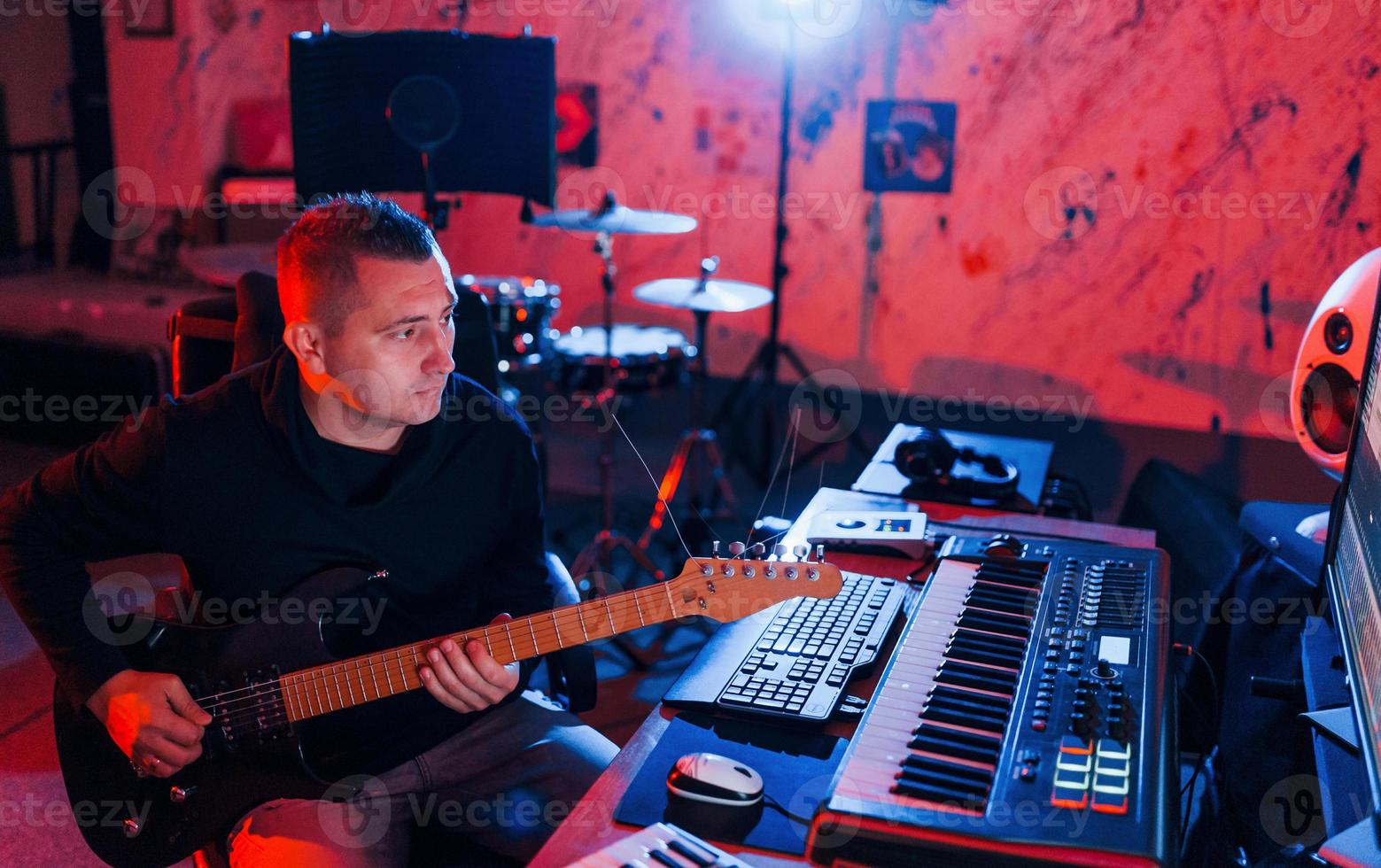 Guitar player have recording session indoors in the studio photo