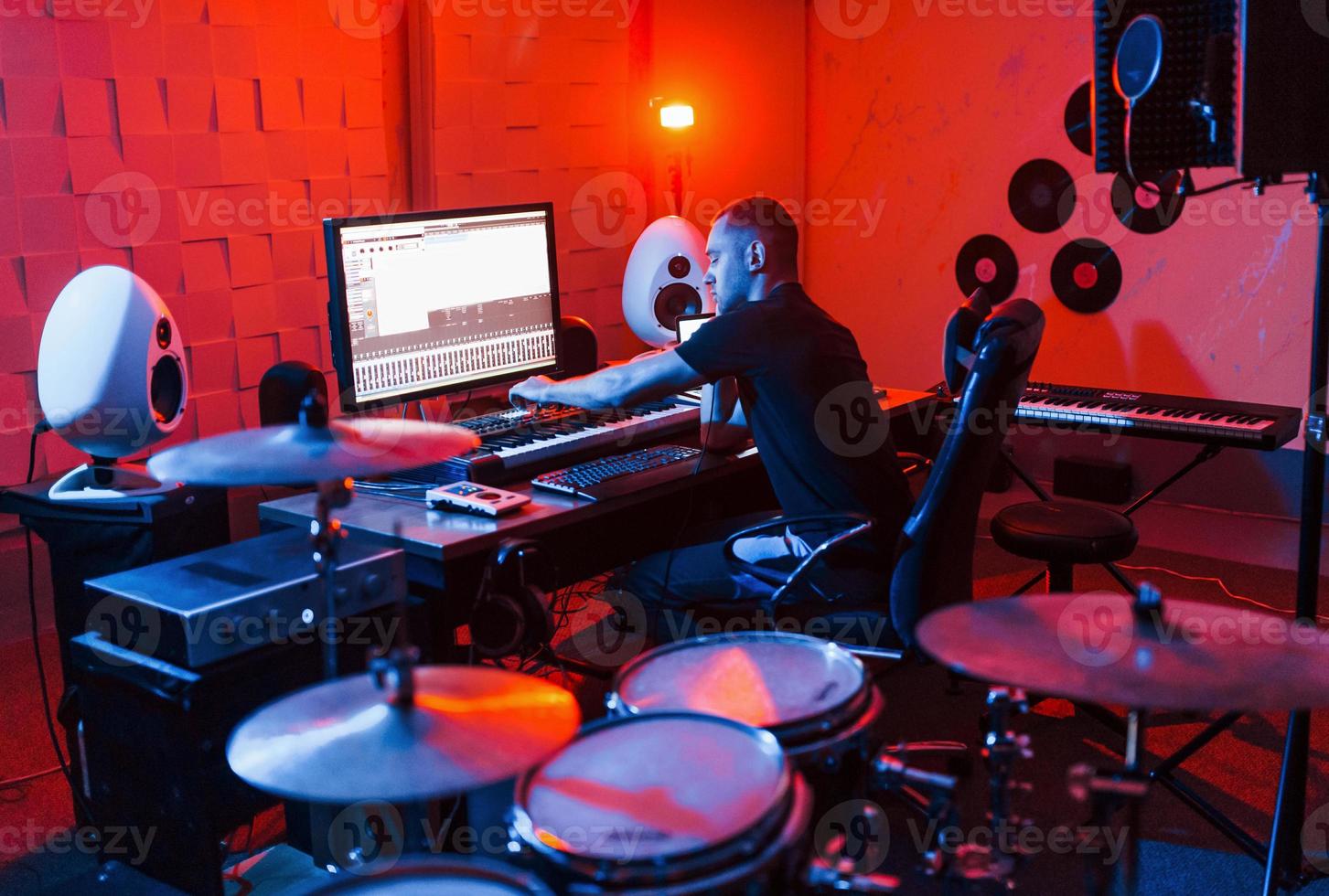 joven ingeniero de sonido trabajando y mezclando música en interiores en el estudio foto