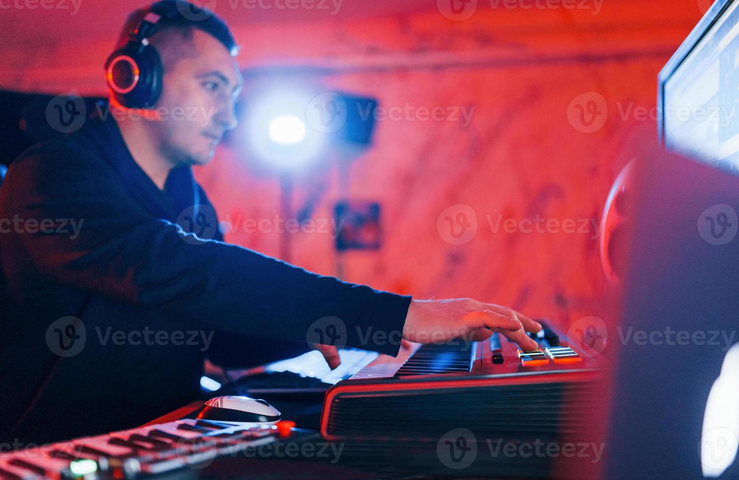 Young soung engineer working and mixing music indoors in the studio photo