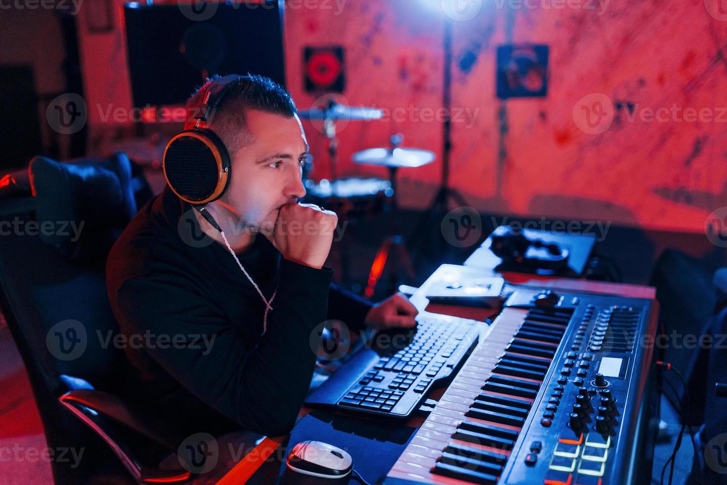 joven ingeniero de sonido trabajando y mezclando música en interiores en el estudio foto