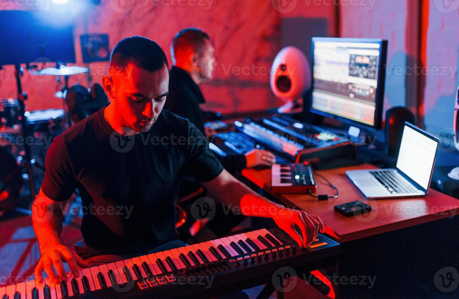 Sound engineer have recording session with piano player indoors in the studio photo