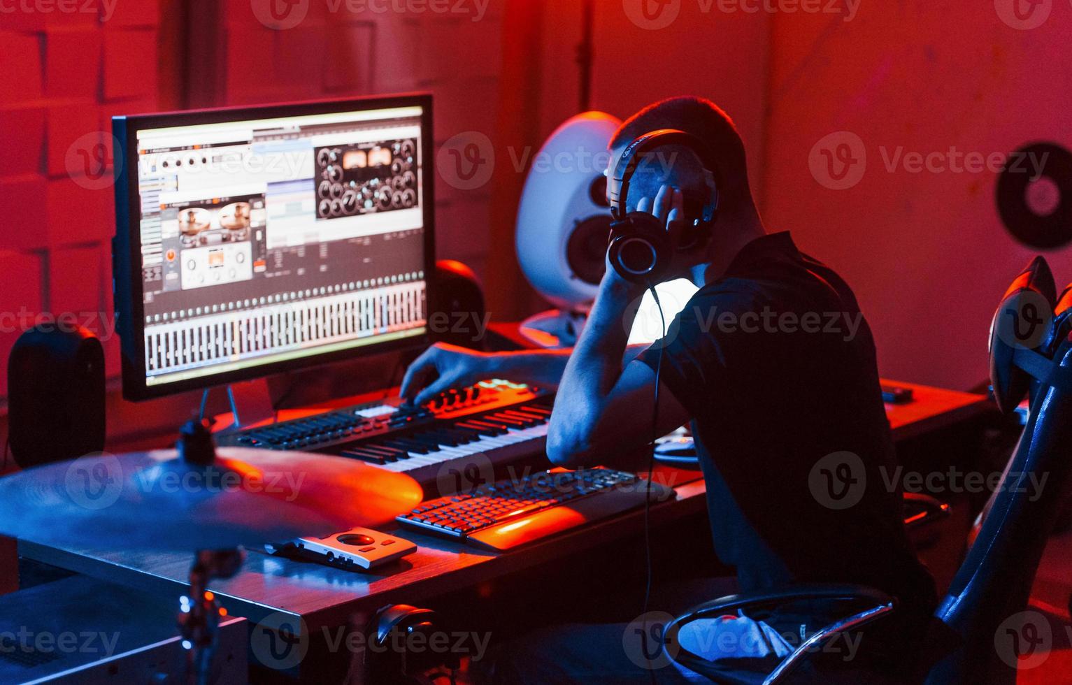 joven ingeniero de sonido trabajando y mezclando música en interiores en el estudio foto