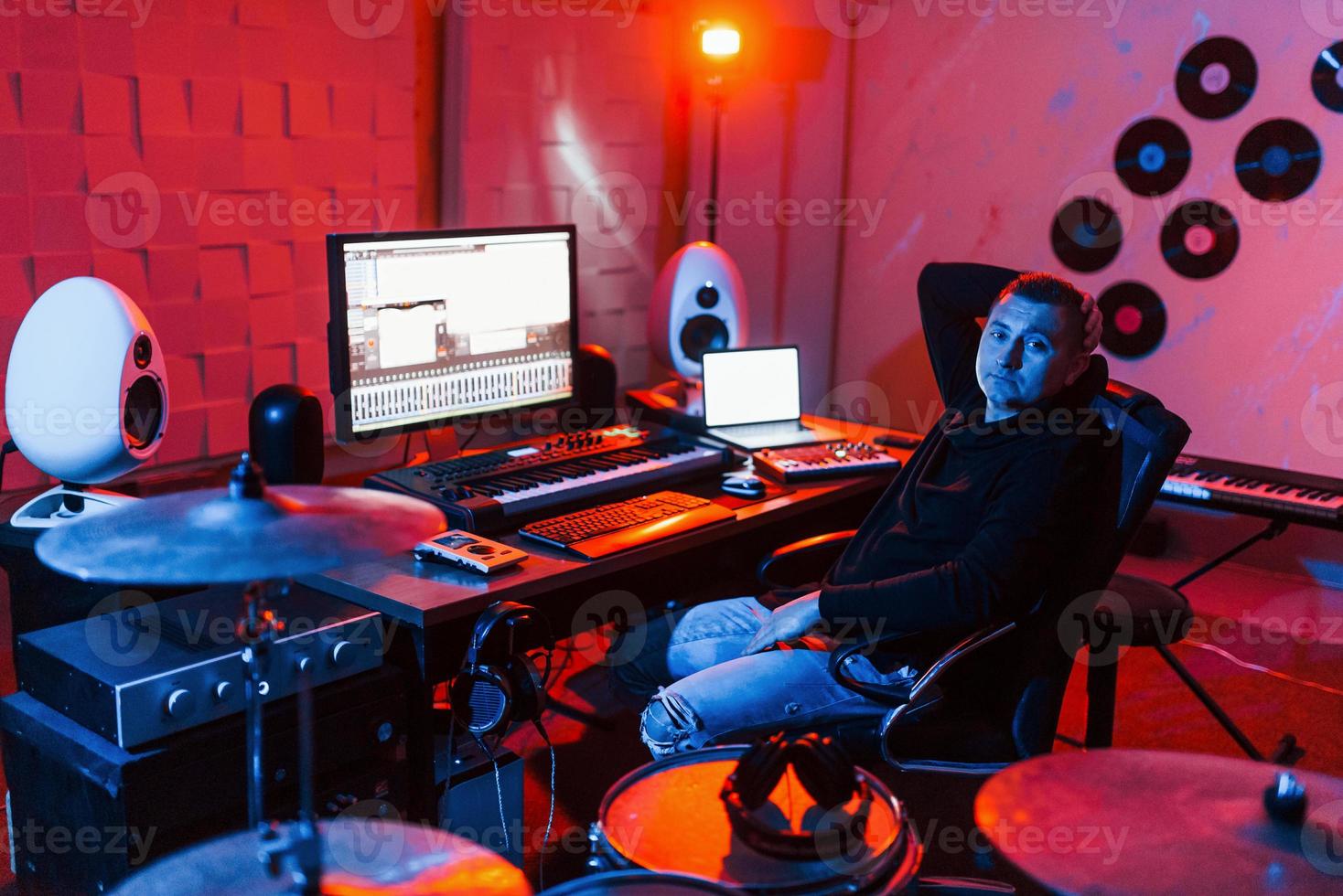 Sound engineer working and mixing music indoors in the studio near drum kit photo