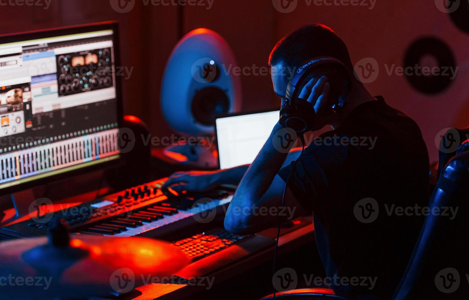 joven ingeniero de sonido trabajando y mezclando música en interiores en el estudio foto