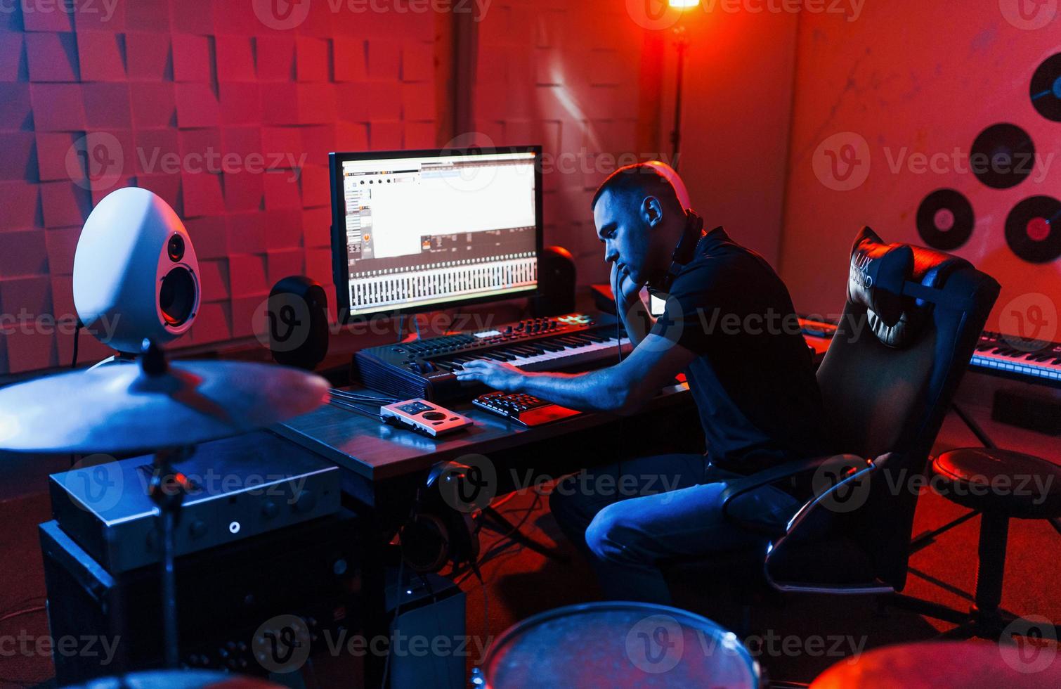 Sound engineer working and mixing music indoors in the studio near drum kit photo