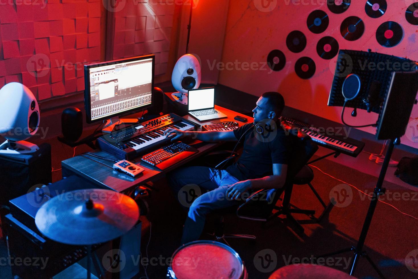 Sound engineer working and mixing music indoors in the studio near drum kit photo