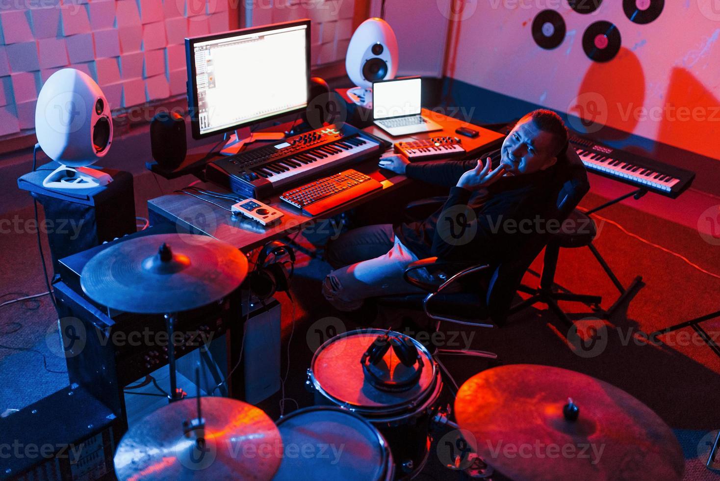 ingeniero de sonido trabajando y mezclando música en el interior del estudio cerca de la batería foto