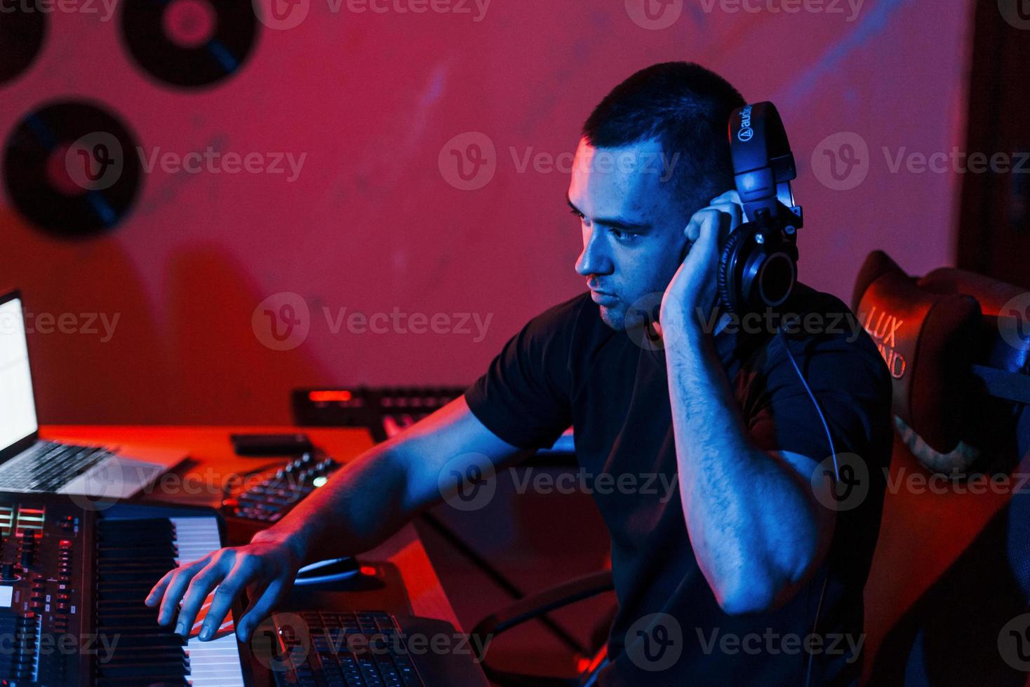 joven ingeniero de sonido trabajando y mezclando música en interiores en el estudio foto