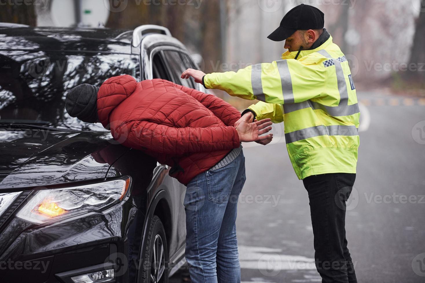 oficial de policía con uniforme verde atrapó el robo de automóviles en la carretera foto