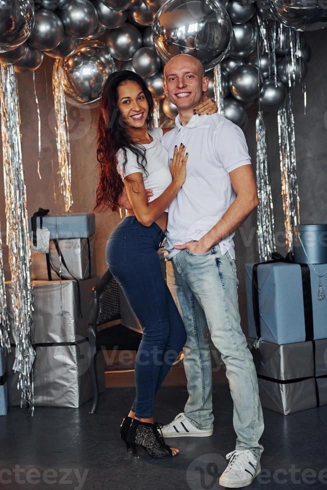 Couple standing in christmas decorated room together and celebrating New Year photo