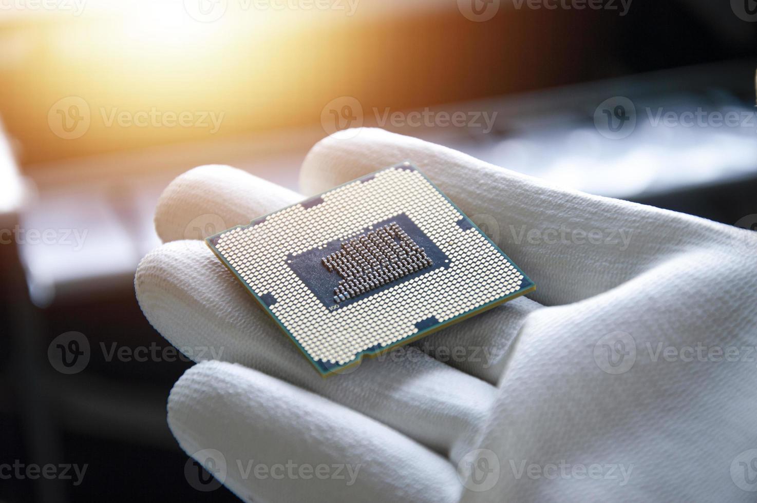 An image of a technician holding a CPU in his hand. photo