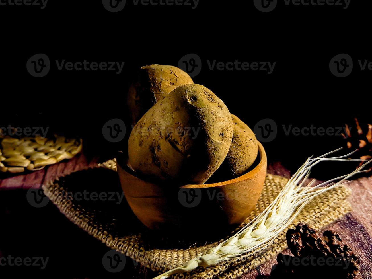 montón de patatas crudas sobre fondo de madera oscura. preparación de sopa o plato de patata, perfecto para el fondo del folleto publicitario foto