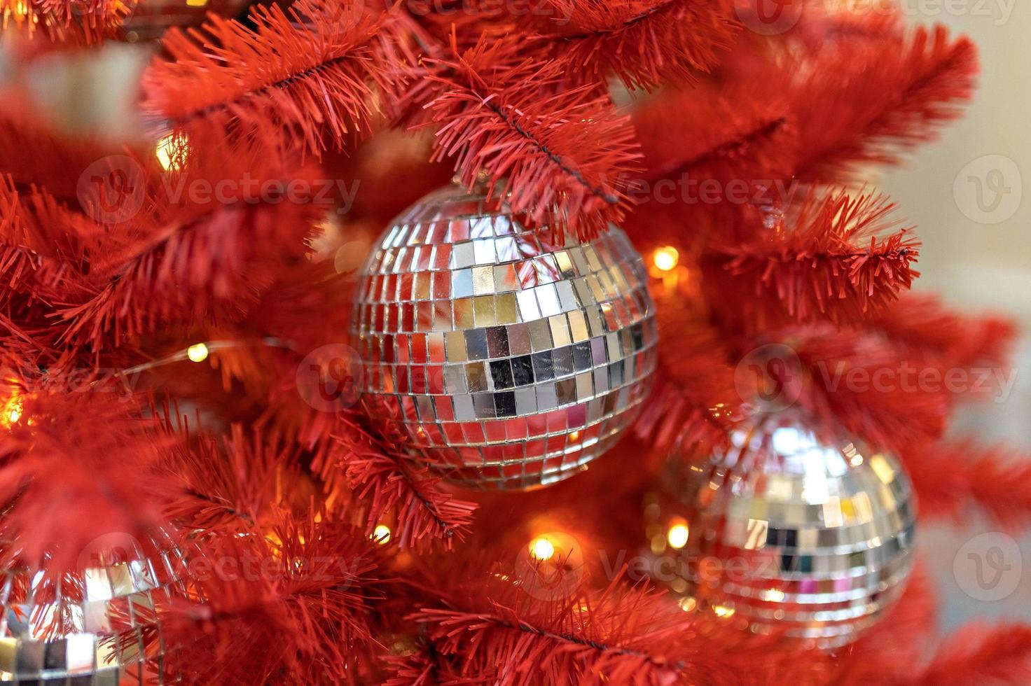 A red Christmas tree decorated with silver toys . Background with bokeh. New Year photo