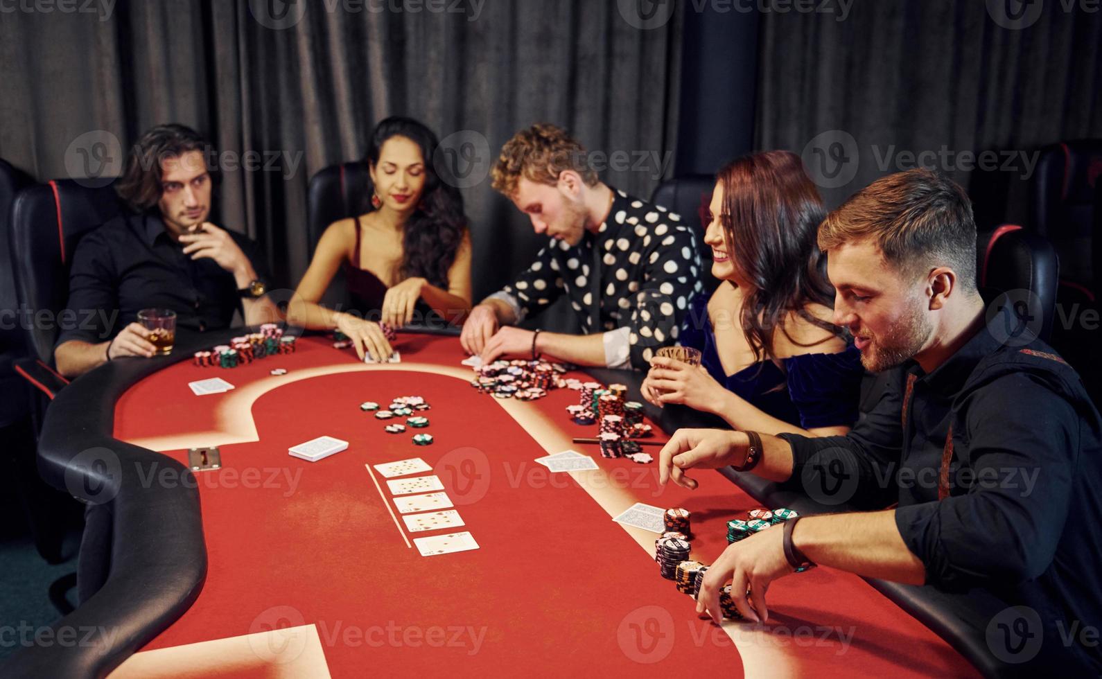 Top view of elegant young people that playing poker in casino photo