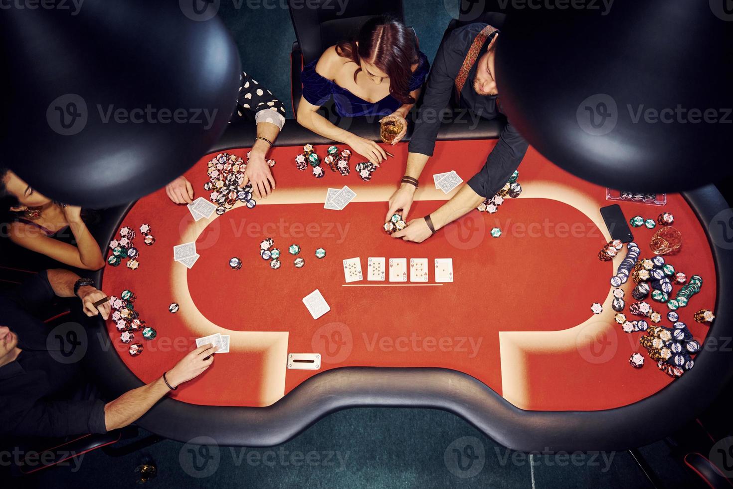 Top view of elegant young people that playing poker in casino photo