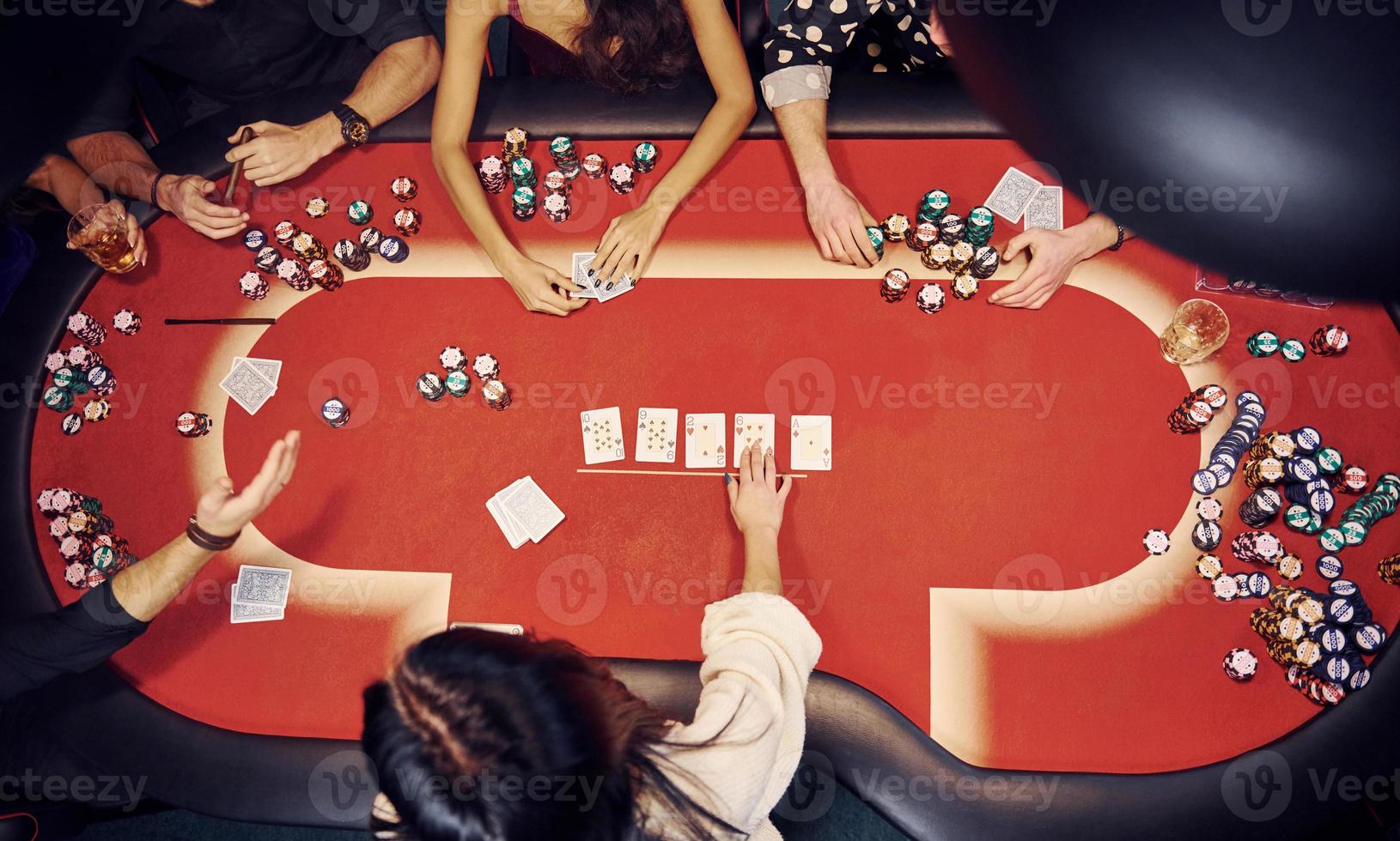 Top view of elegant young people that playing poker in casino photo
