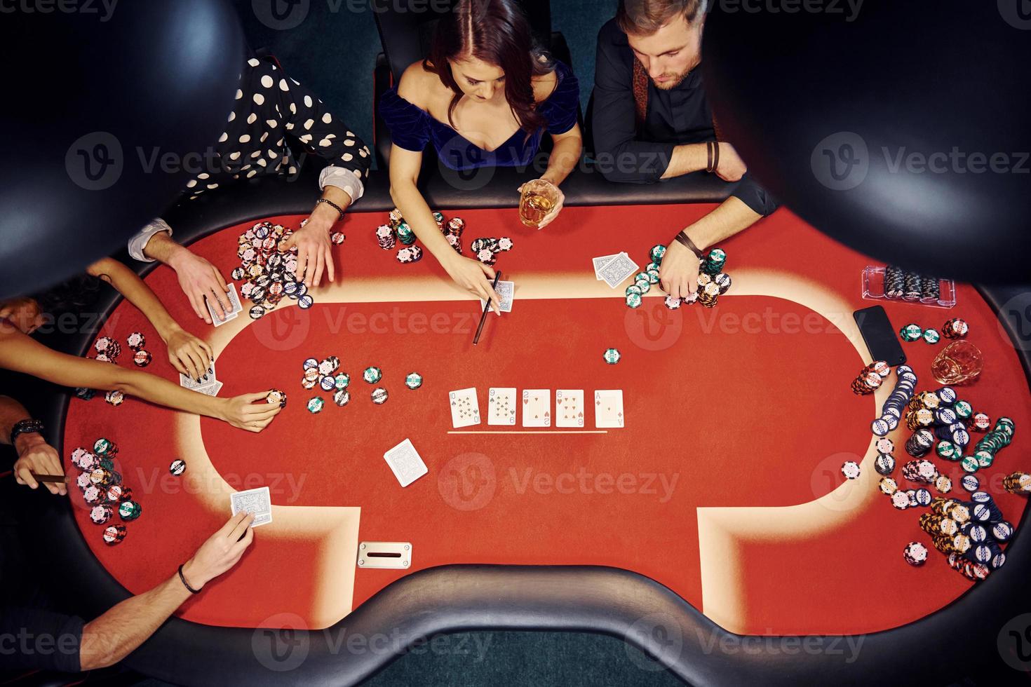 Top view of elegant young people that playing poker in casino photo