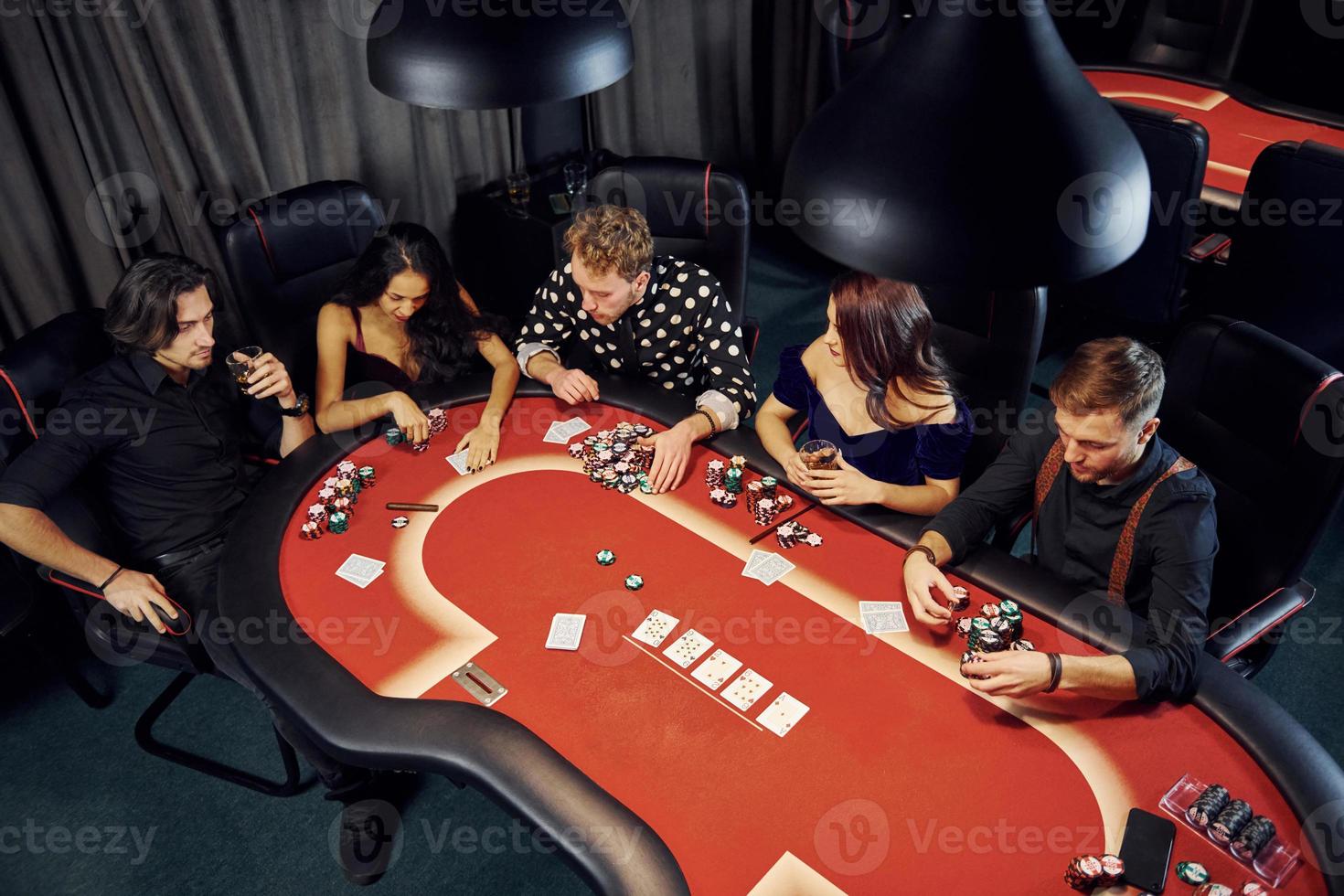 Top view of elegant young people that playing poker in casino photo