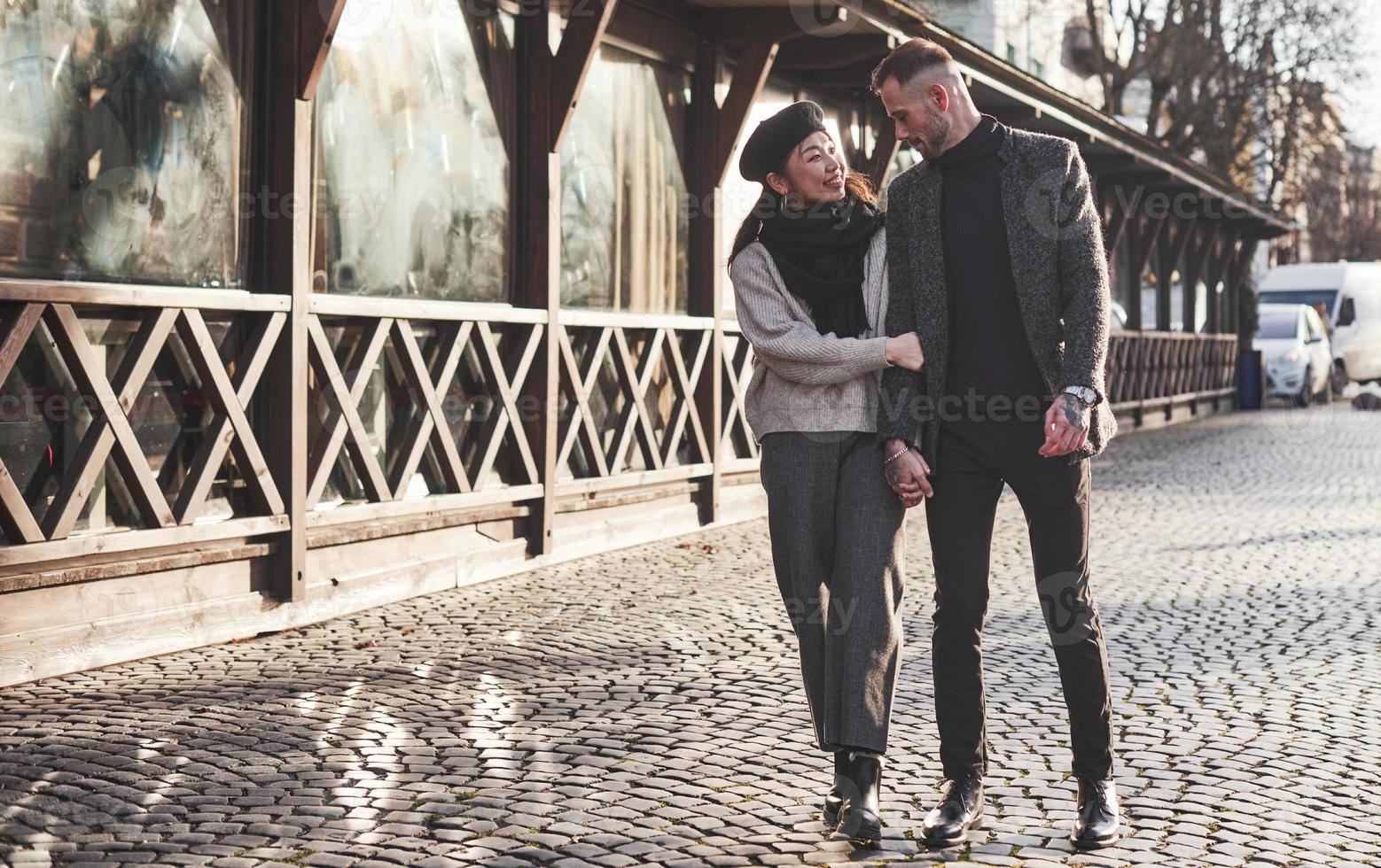 Lovely multiracial couple have a walk in the city and embracing each other photo